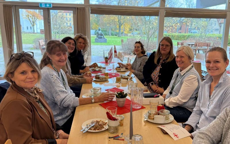 Foto af en fællesmiddag ved et langbord i kantinen på Filadelfia