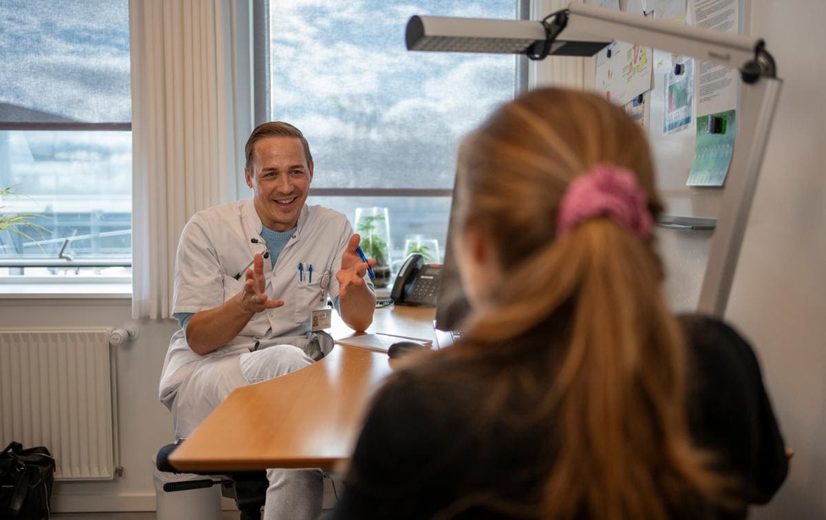 Læge Harald Møller i samtale med patient på Filadelfias ambulatorie