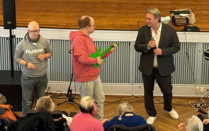 Johnny Hansen optræder på Filadelfia sammen med to borgere med hver sin luftguitar, 2026